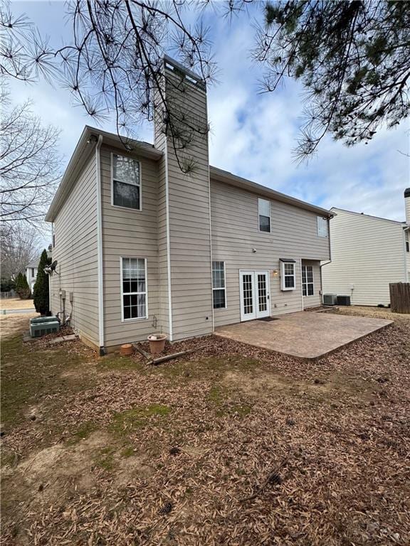 back of house with a patio, french doors, a chimney, and central AC unit