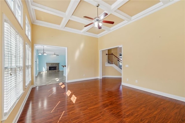 2143 Great Shoals Cir, Lawrenceville, GA 30045 - unfurnished living room featuring a fireplace, a high ceiling, coffered ceiling, and dark wood-style flooring