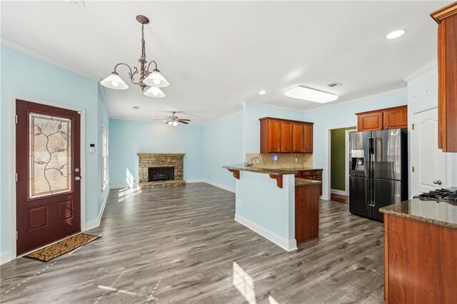 2143 Great Shoals Cir, Lawrenceville, GA 30045 - kitchen with stainless steel fridge, brown cabinetry, open floor plan, a kitchen breakfast bar, and decorative light fixtures