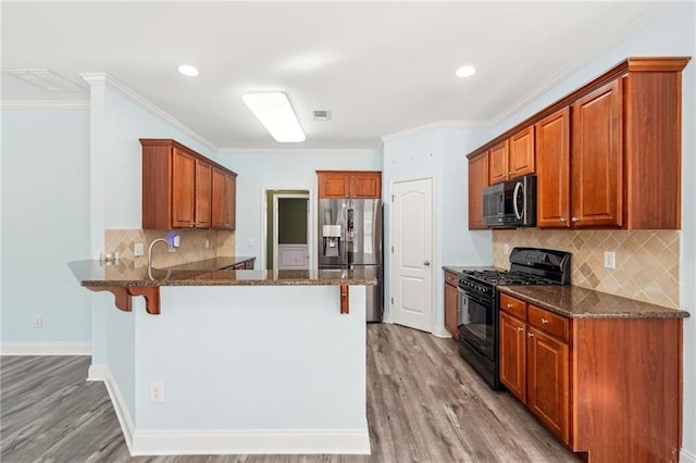 2143 Great Shoals Cir, Lawrenceville, GA 30045 - kitchen with dark stone countertops, stainless steel appliances, a peninsula, and a kitchen bar
