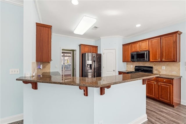 2143 Great Shoals Cir, Lawrenceville, GA 30045 - kitchen featuring a breakfast bar area, a peninsula, visible vents, appliances with stainless steel finishes, and dark stone countertops