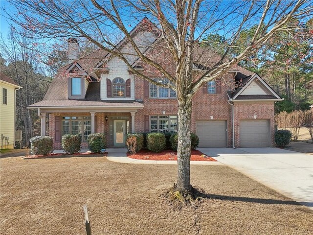 2143 Great Shoals Cir, Lawrenceville, GA 30045 - view of front of home featuring a garage, concrete driveway, a chimney, a front yard, and brick siding