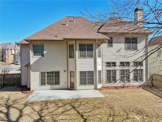 2143 Great Shoals Cir, Lawrenceville, GA 30045 - back of property featuring a chimney, a patio area, a lawn, and a fenced backyard