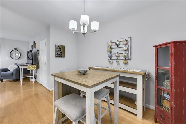 dining area with a notable chandelier and light hardwood / wood-style floors