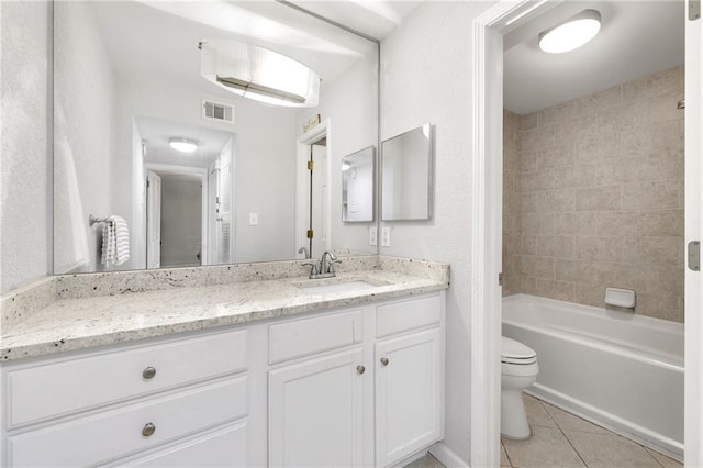 full bathroom featuring vanity, tiled shower / bath, tile patterned floors, and toilet