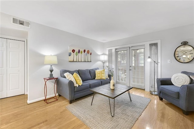 living room featuring french doors and light wood-type flooring