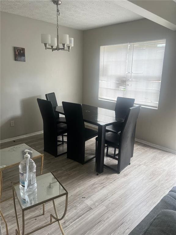 dining room featuring hardwood / wood-style flooring, a textured ceiling, and a notable chandelier