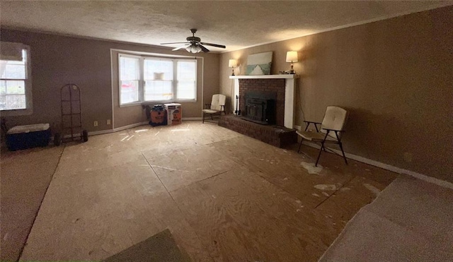 unfurnished living room featuring baseboards, a textured ceiling, ceiling fan, and a fireplace