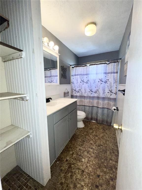 full bath with vanity, a shower with shower curtain, toilet, and wainscoting