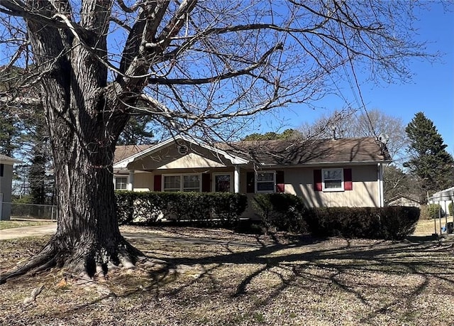 ranch-style home featuring fence