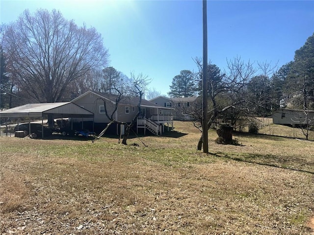 view of yard with an attached carport and stairway