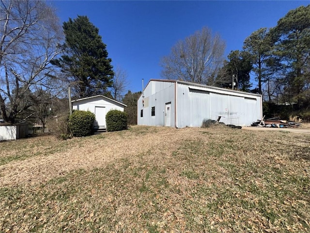 view of side of property featuring an outbuilding, a detached garage, and a pole building