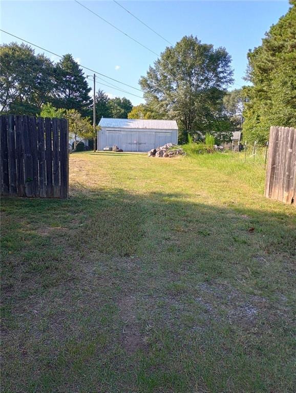 view of yard with an outbuilding, fence, and a pole building