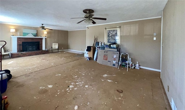 unfurnished living room with baseboards, ceiling fan, a fireplace, and ornamental molding