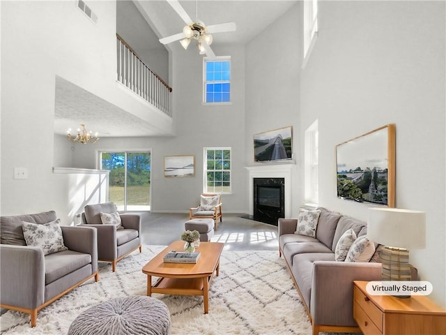 living room featuring a high end fireplace, a high ceiling, and ceiling fan