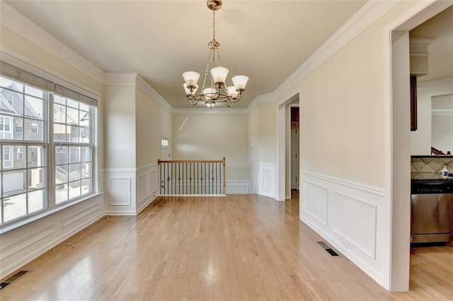 unfurnished room featuring light wood-style flooring, visible vents, and a chandelier