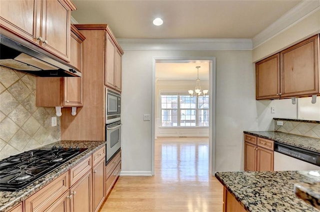 kitchen featuring crown molding, stainless steel appliances, light wood-style flooring, dark stone countertops, and under cabinet range hood