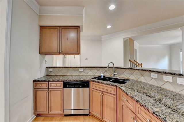 kitchen featuring dishwasher, stone countertops, a sink, and decorative backsplash