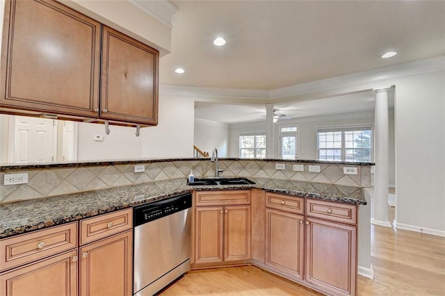 kitchen with dishwasher, tasteful backsplash, dark stone countertops, and a sink