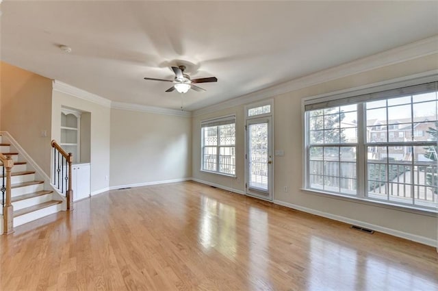 spare room featuring visible vents, light wood-style flooring, stairway, ornamental molding, and built in shelves