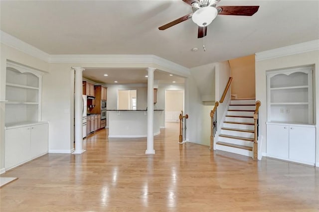 unfurnished living room with built in shelves, light wood-type flooring, ornamental molding, and ornate columns