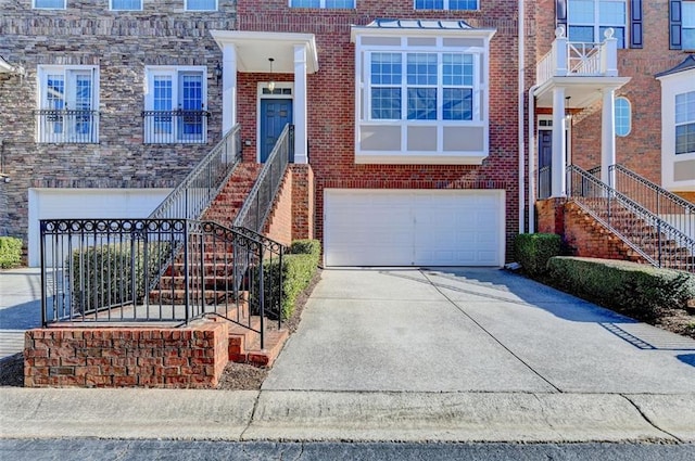 view of front of property with an attached garage, stairs, concrete driveway, and brick siding