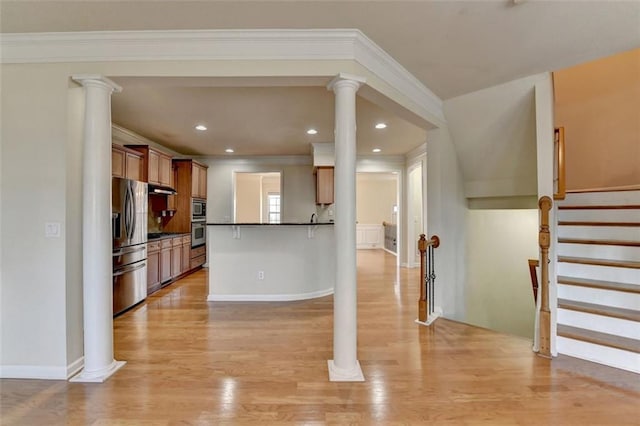 kitchen featuring dark countertops, decorative columns, and a breakfast bar