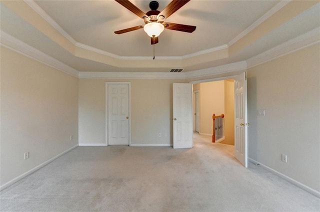 unfurnished bedroom featuring a tray ceiling, visible vents, and crown molding