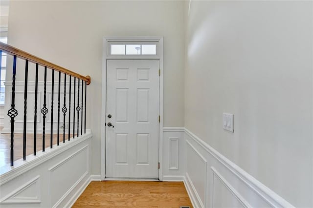 doorway to outside featuring light wood-style flooring and a decorative wall