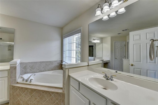 bathroom featuring a bath, visible vents, a shower with shower door, and vanity