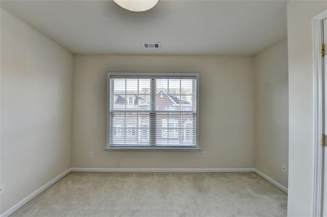 empty room featuring light carpet, a healthy amount of sunlight, and visible vents