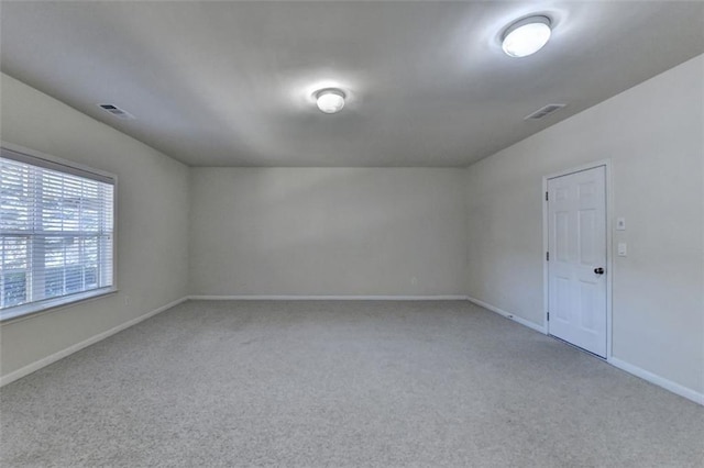 empty room featuring carpet floors, baseboards, and visible vents