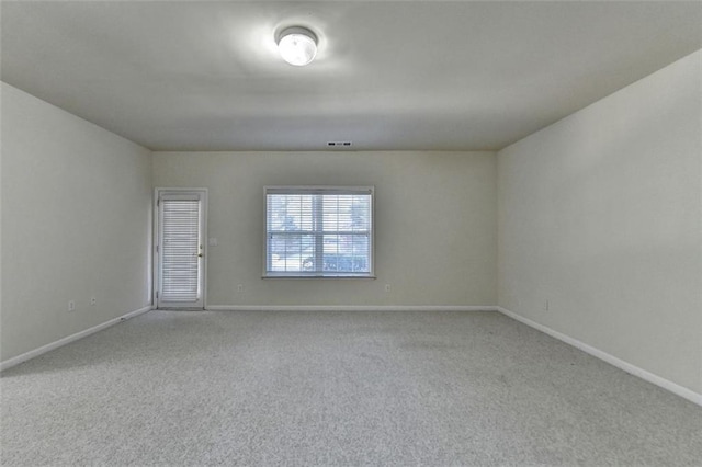 carpeted spare room with visible vents and baseboards