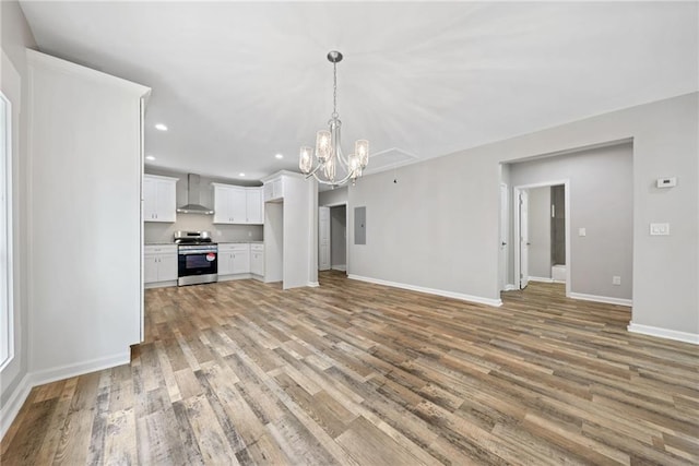 unfurnished living room featuring a notable chandelier, electric panel, and light wood-type flooring