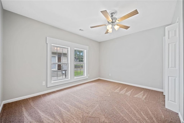 carpeted spare room with ceiling fan