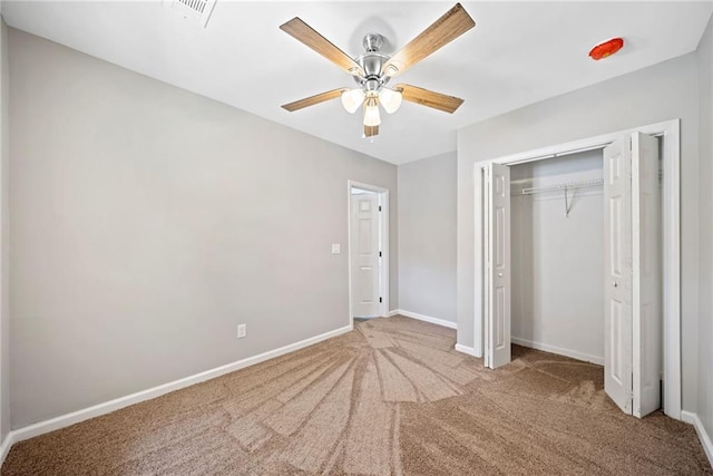 unfurnished bedroom with light colored carpet, a closet, and ceiling fan