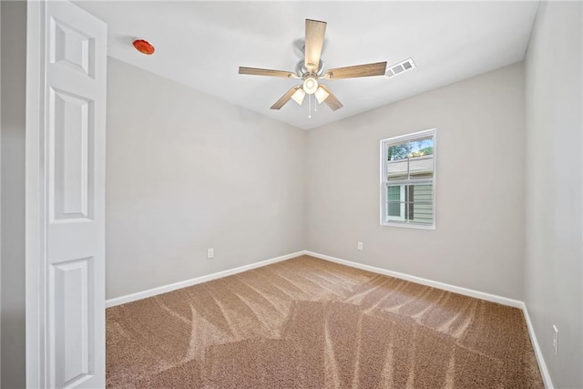 carpeted spare room featuring ceiling fan