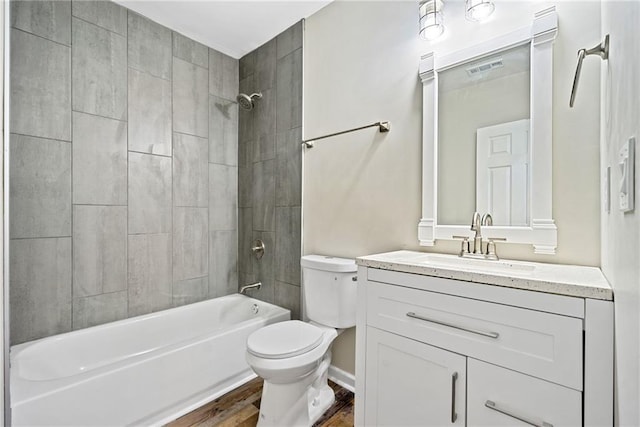 full bathroom featuring hardwood / wood-style flooring, vanity, toilet, and tiled shower / bath combo