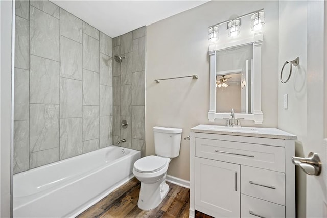 full bathroom with vanity, tiled shower / bath combo, toilet, and hardwood / wood-style flooring