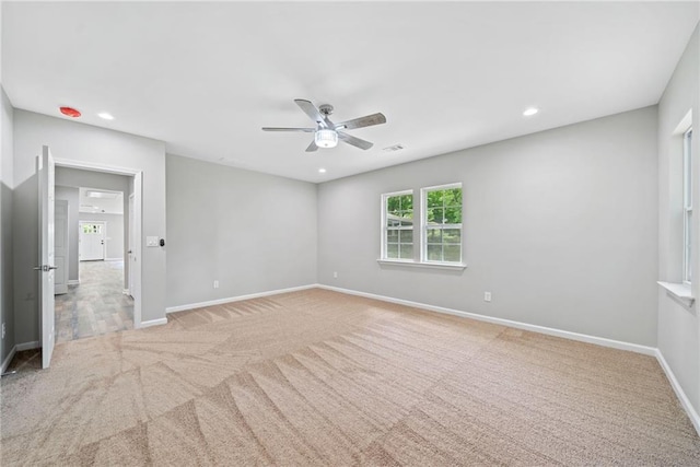 unfurnished room with light colored carpet and ceiling fan