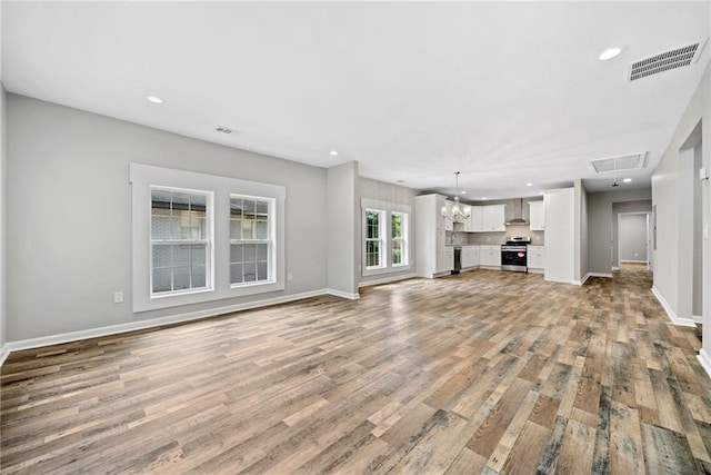 unfurnished living room with hardwood / wood-style floors and a chandelier