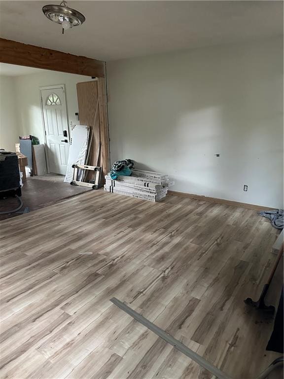 interior space with beam ceiling and light wood-type flooring