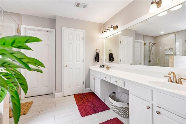 full bath with double vanity, a sink, visible vents, and a shower stall