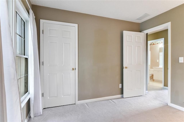 unfurnished bedroom featuring carpet, visible vents, and baseboards