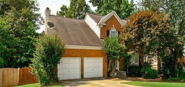 view of front of home featuring a garage, concrete driveway, a chimney, fence, and brick siding