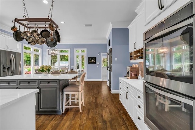 4020 Devereux Chase, Roswell, GA 30075 - kitchen with stainless steel appliances, white cabinetry, gray cabinetry, dark wood-style flooring, and ornamental molding