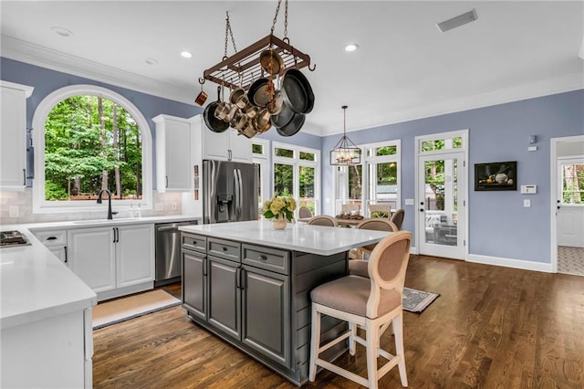 4020 Devereux Chase, Roswell, GA 30075 - kitchen with appliances with stainless steel finishes, a sink, white cabinetry, a breakfast bar, and light countertops