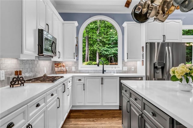 4020 Devereux Chase, Roswell, GA 30075 - kitchen featuring appliances with stainless steel finishes, light countertops, tasteful backsplash, white cabinetry, and crown molding