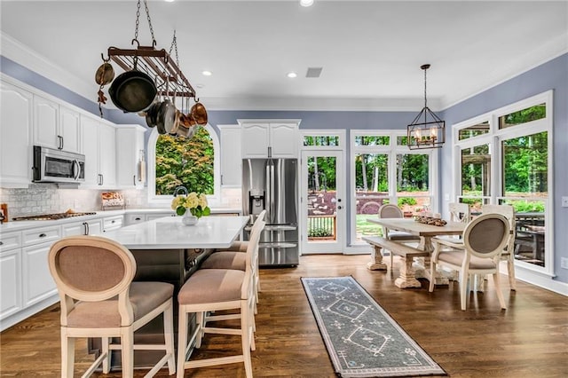 4020 Devereux Chase, Roswell, GA 30075 - kitchen featuring stainless steel appliances, a center island, plenty of natural light, backsplash, and ornamental molding