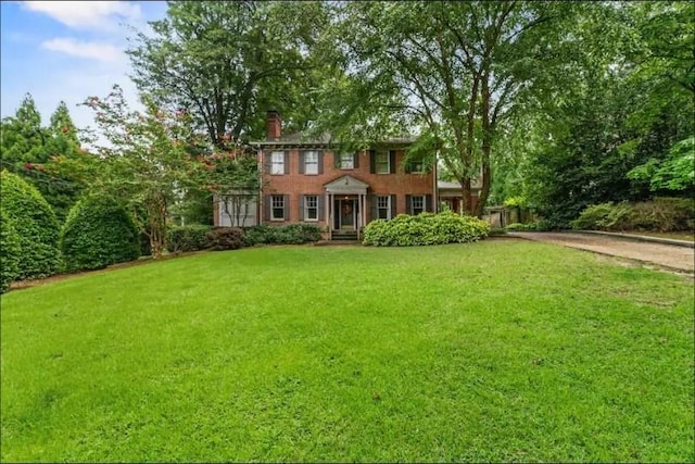 colonial house featuring a front lawn